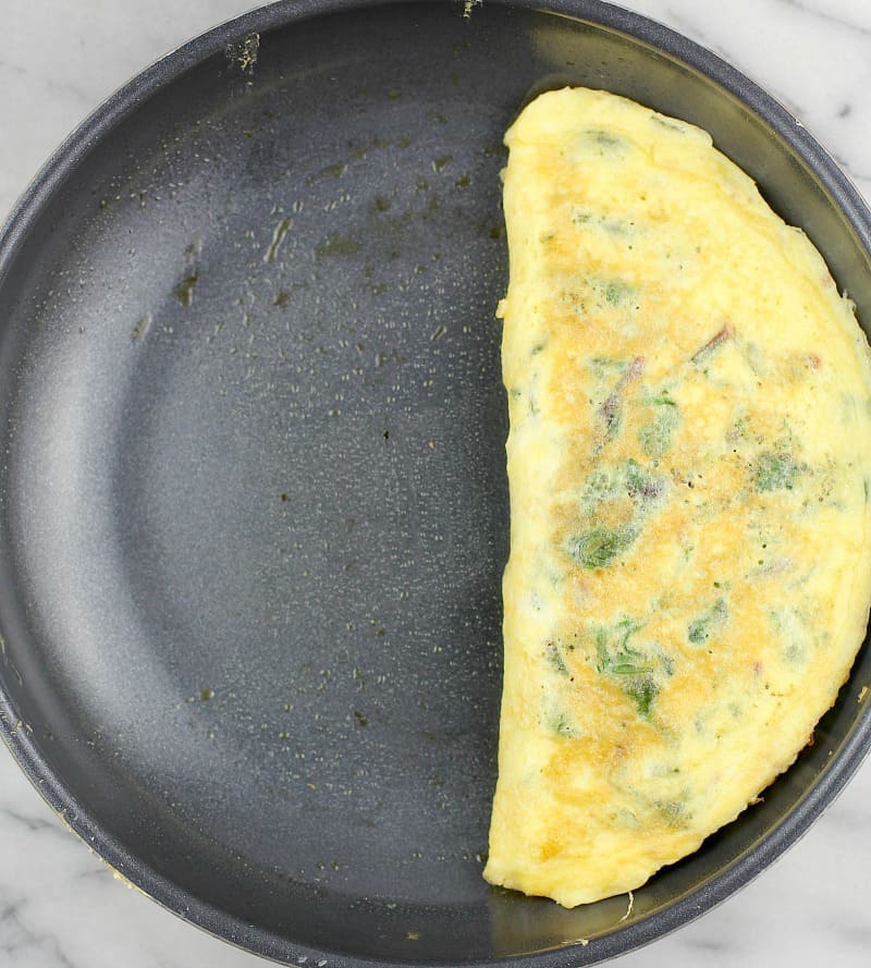 Top down view of the formed and cooked omelet in a skillet