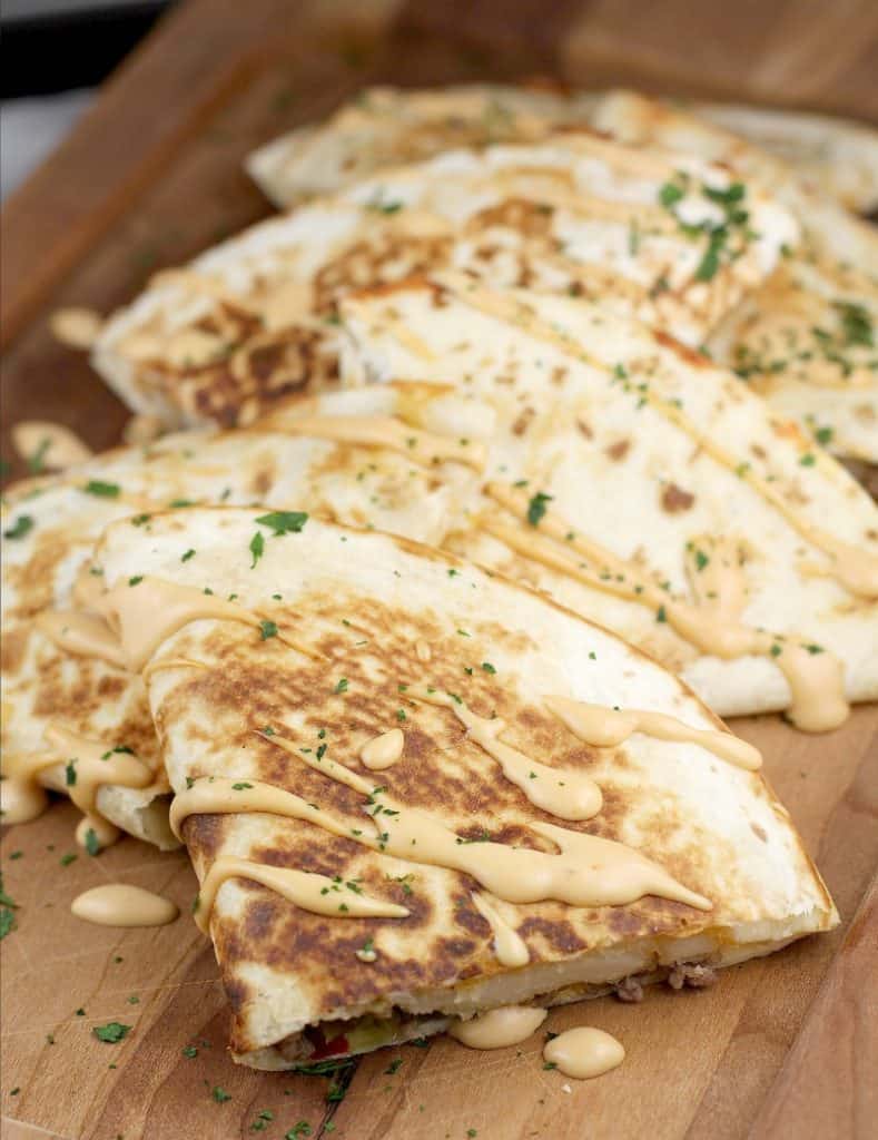 top/angle view of finished quesadilla on a wood serving plate to show how to serve them