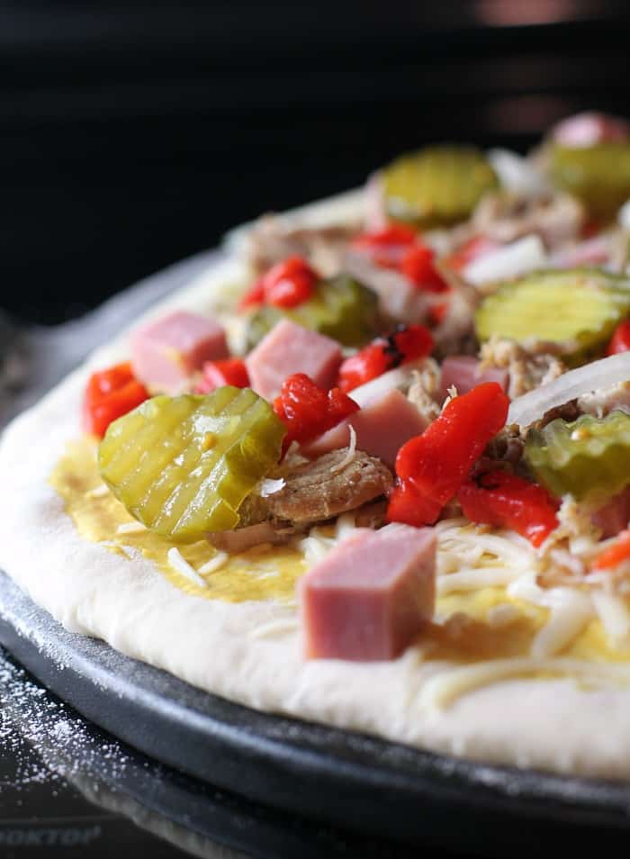 side view showing the toppings loaded on the uncooked dough, not yet covered with cheese