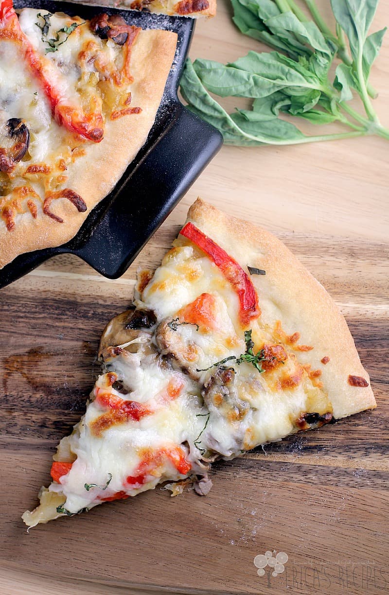 top view of a slice of French Onion Pizza on a wood cutting board