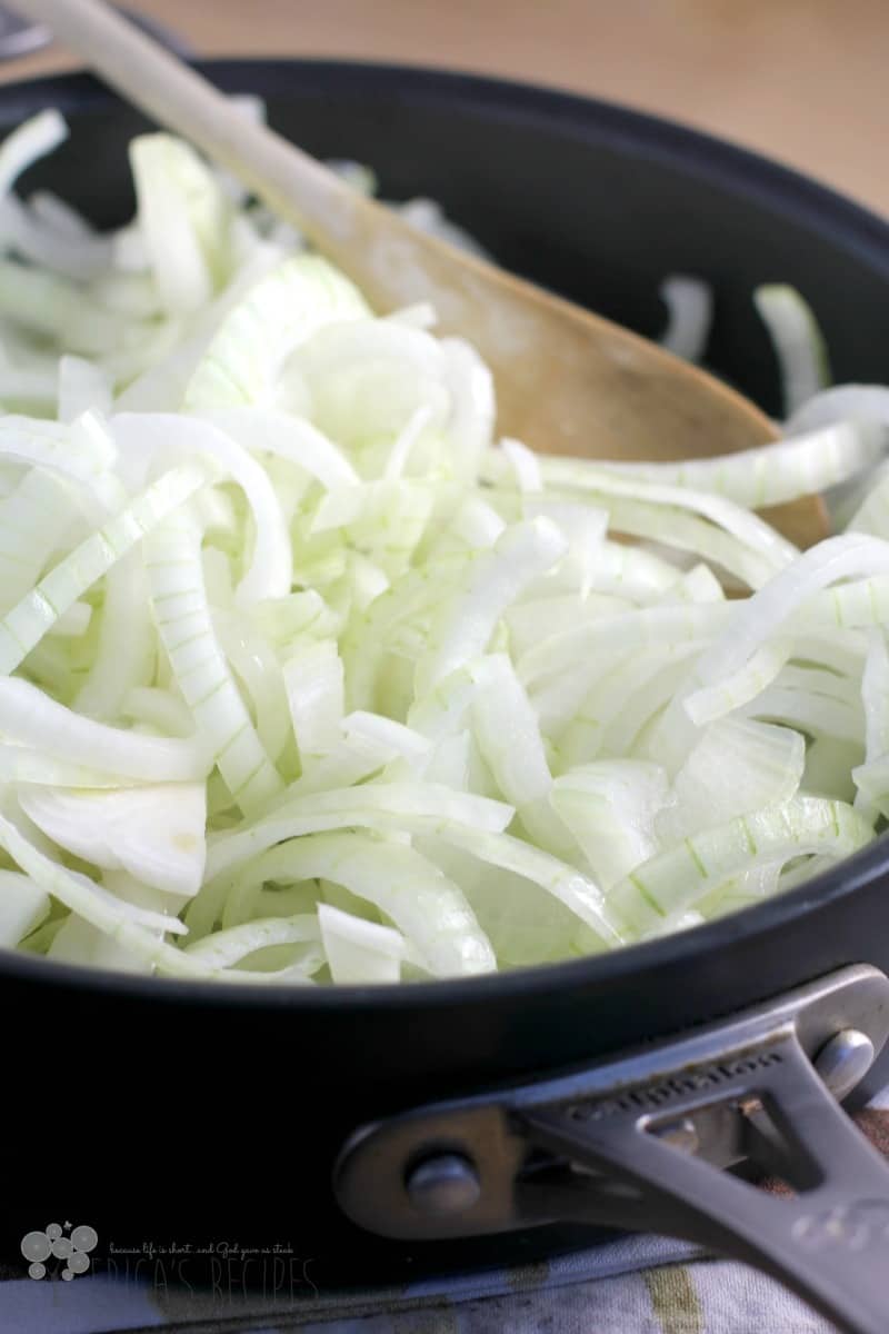 thinly sliced raw onions in a black skillet