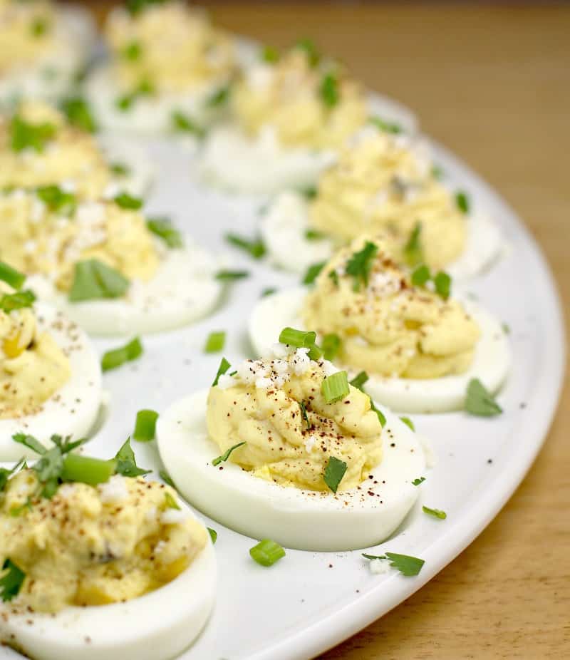 the finished Mexican street corn deviled eggs arranged on a white serving plate
