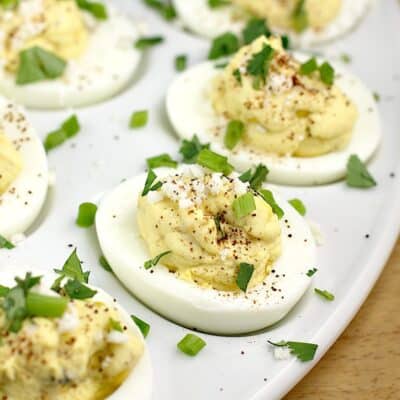 Mexican street corn deviled eggs on a white plate, on a cutting board