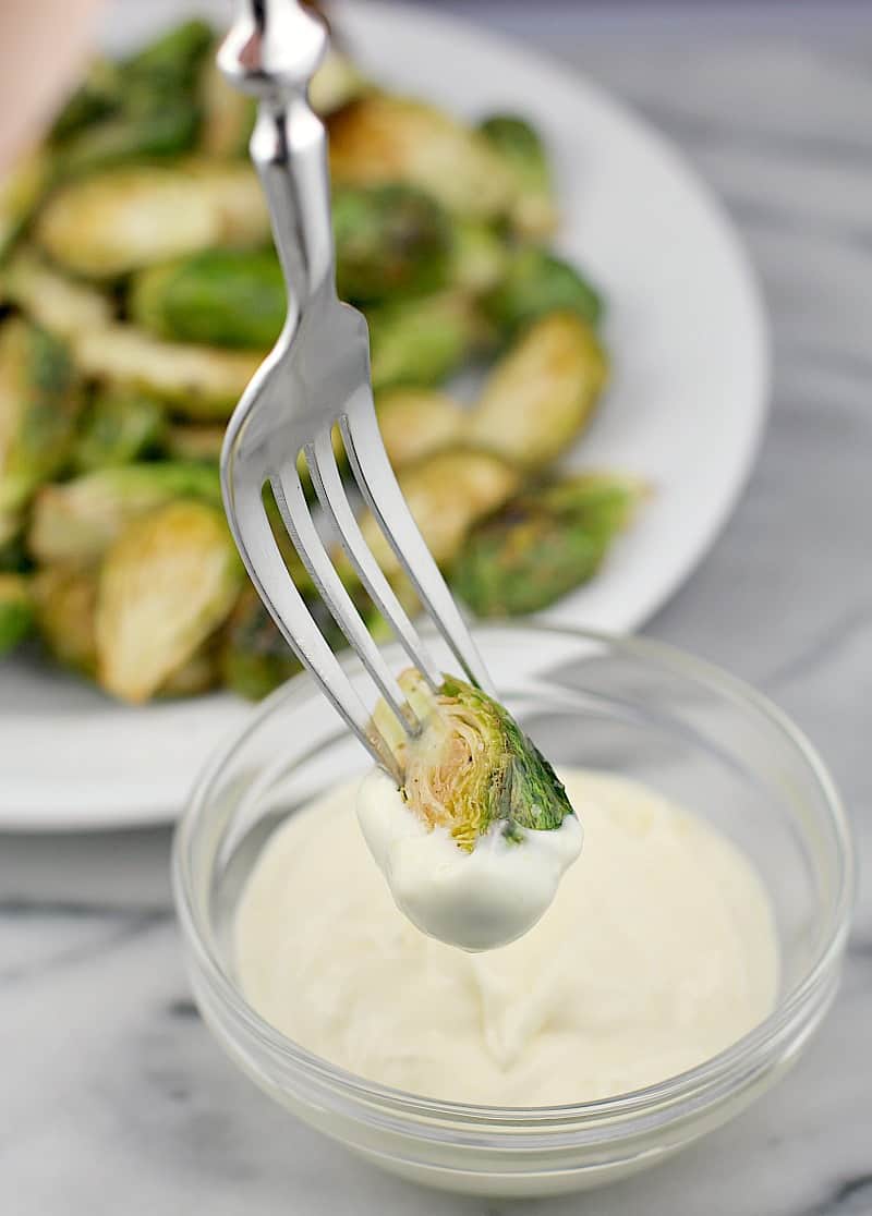 fork dipping a brussel sprout in aioli