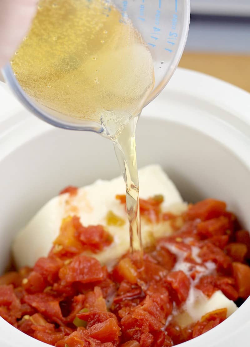 view of the beer being poured into a crock pot with the queso blanco recipe