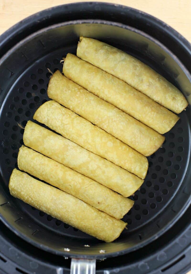 rolled corn tortillas in an air fryer basket