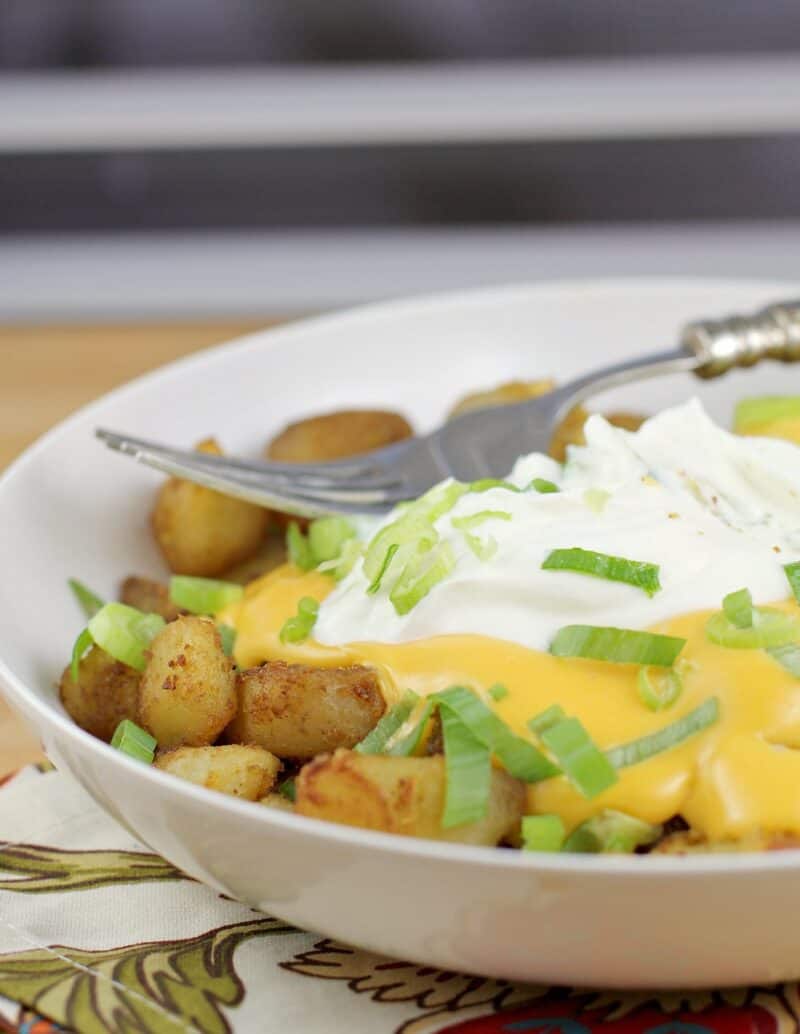 fiesta potatoes in a white bowl with fork on top