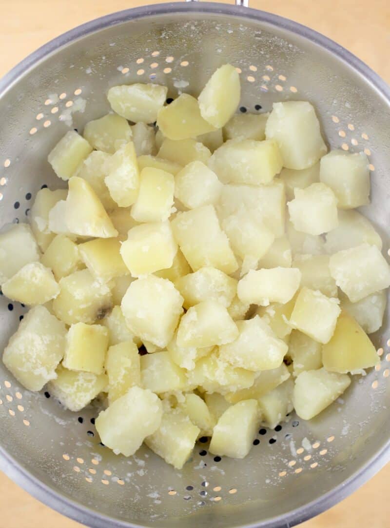 par-boiled potatoes draining in a colander