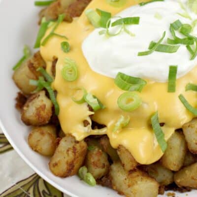 potatoes topped with cheese and sour cream in a white bowl