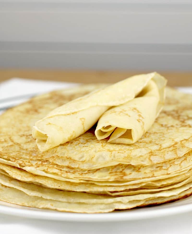 stack of crepes with a rolled crepe on top