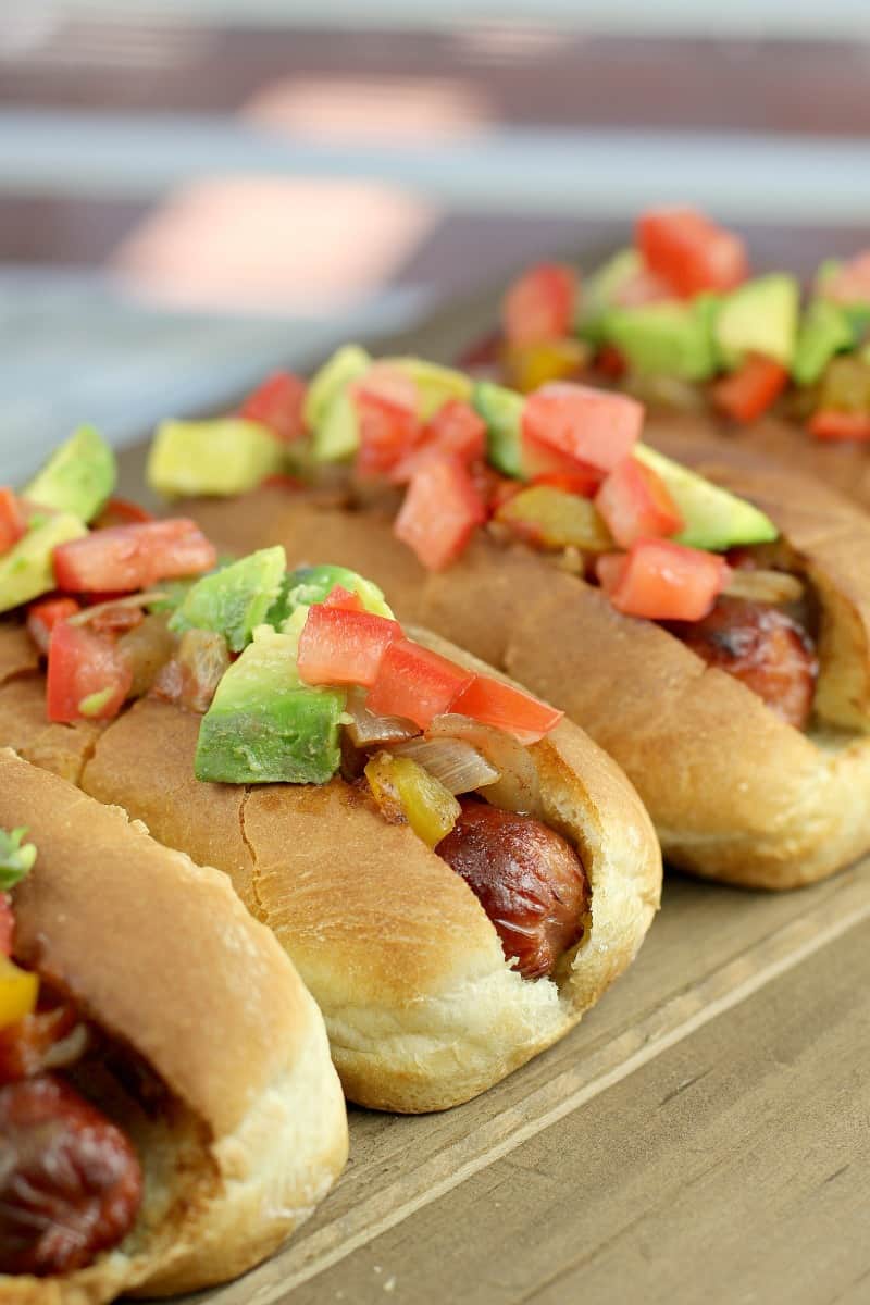 4 hot dogs in buns topped with sweet pepper relish