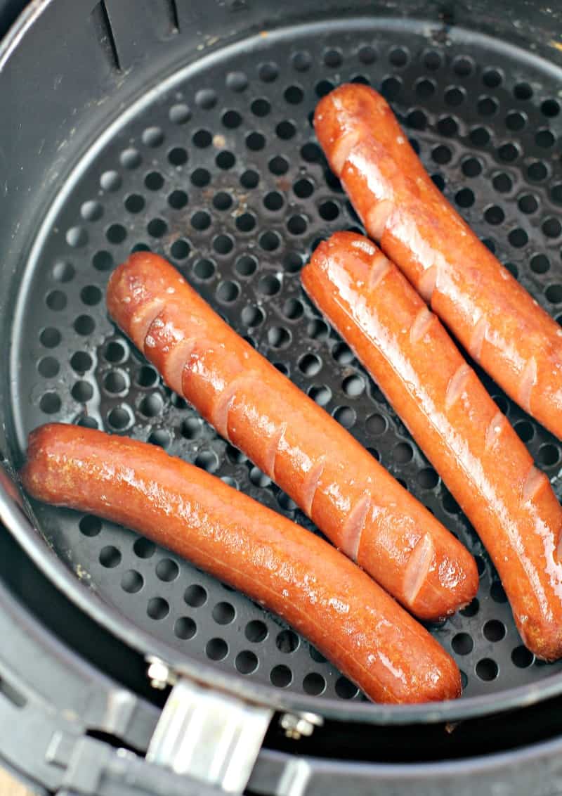 four cooked hot dogs in an air fryer