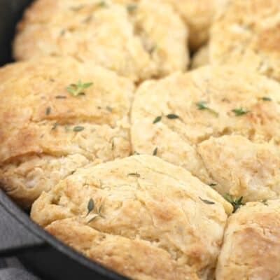 cooked biscuits in a pan with thyme sprinkled over
