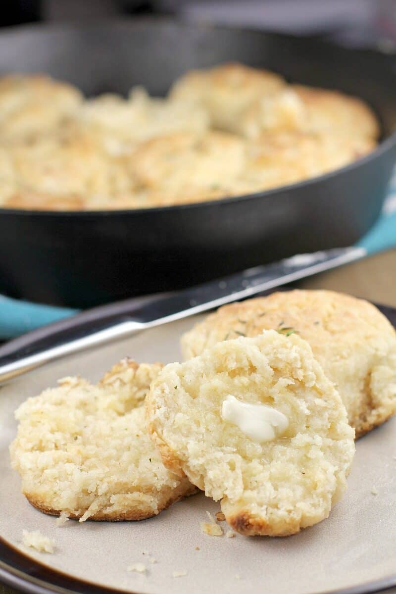 split biscuit on a plate with a pat of butter melting