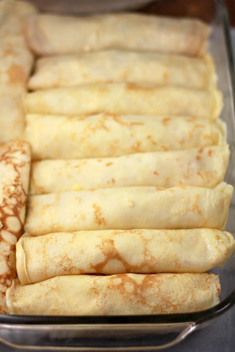 assembled crepes in pyrex bake dish before cooking