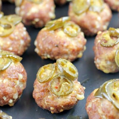 smoked sausage balls topped with jalapenos on metal pan