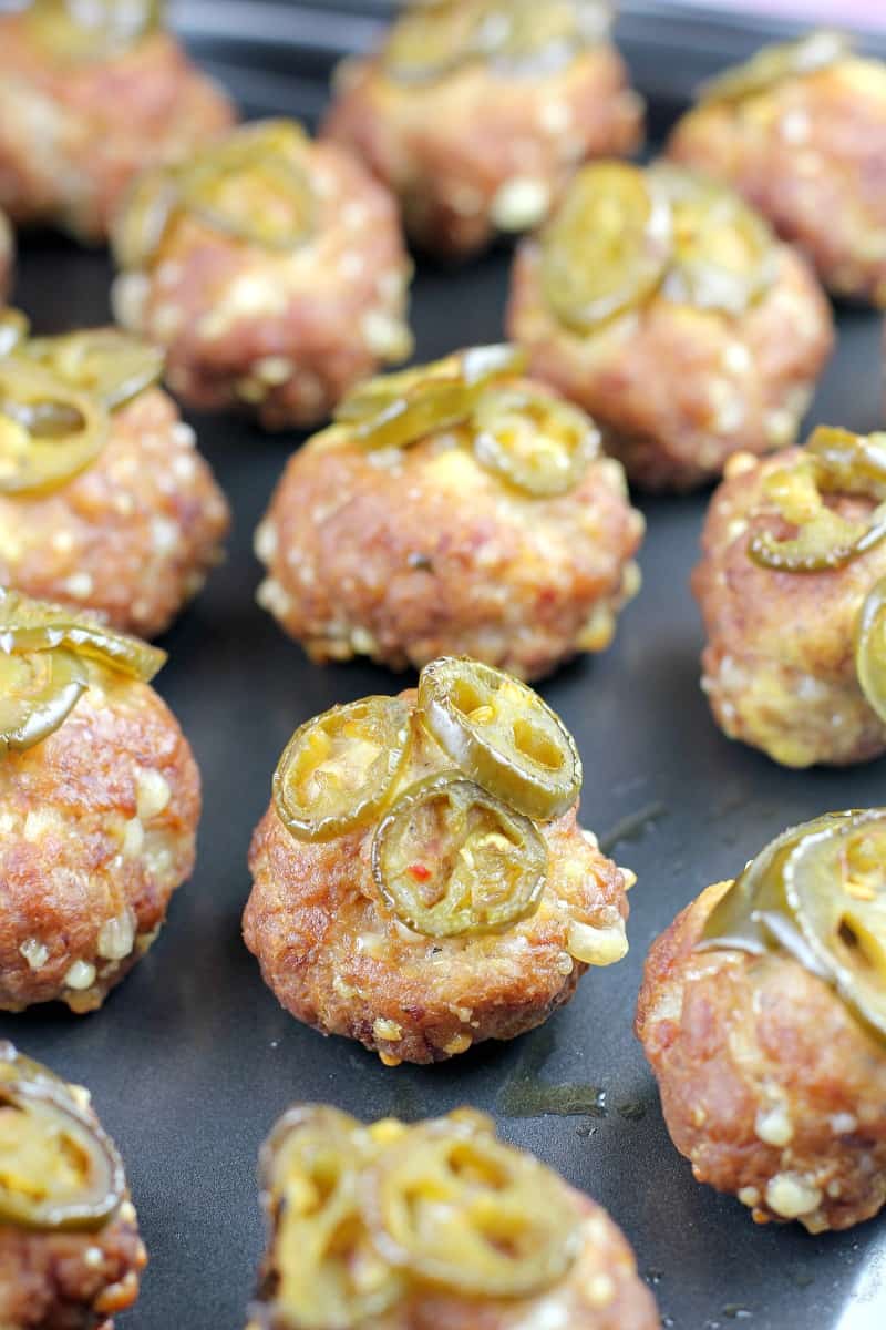 smoked sausage balls topped with jalapenos on metal pan