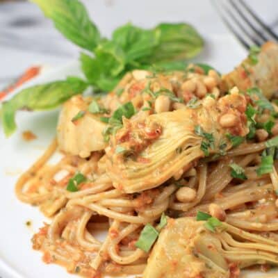 plated sun dried tomato pesto pasta on a white plate