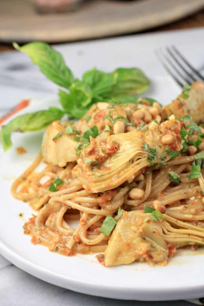 plated sun dried tomato pesto pasta on a white plate