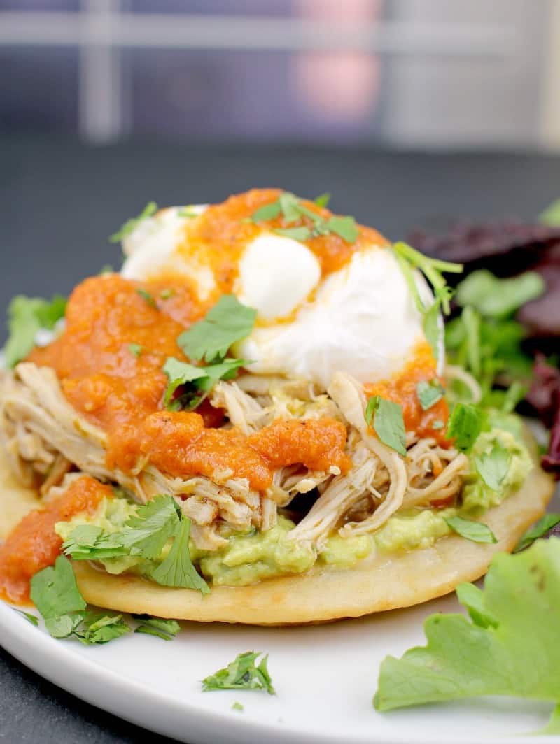 assembled recipe showing a tortilla, guacamole, chicken, egg, and ranchero sauce