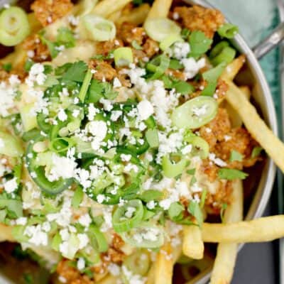 top down view of Mexican poutine in a metal dish on a blue napkin