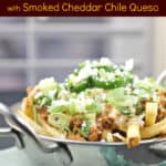 image for Pinterest sharing of prepared recipe in metal bowl on blue napkin with text overlay of recipe title Mexican Poutine with Smoked Cheddar Chile Queso