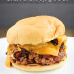 image for pinterest of plated sloppy joe sandwich with text overlay of recipe title Bacon Cheddar Beer Grilled Sloppy Joes
