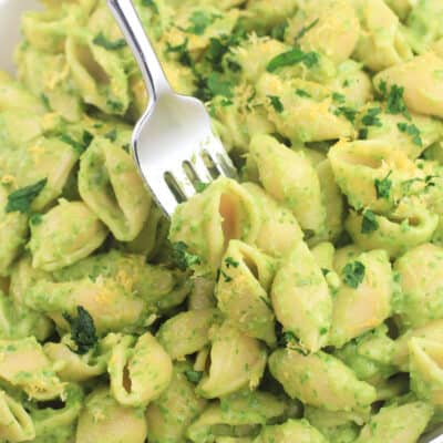 avocado spinach pasta in a white bowl with a fork
