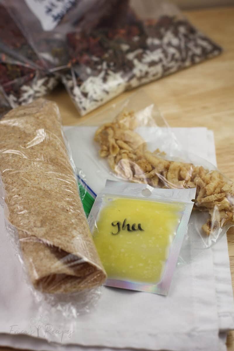 in plastic packaging, a tortilla, ghee, and onions on white napkin