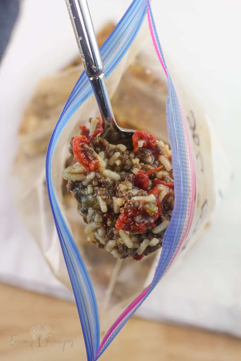 open ziploc bag with spoon lifting up prepared sloppy joes