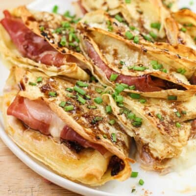 close view of prepared crepes showing prosciutto and melted cheese