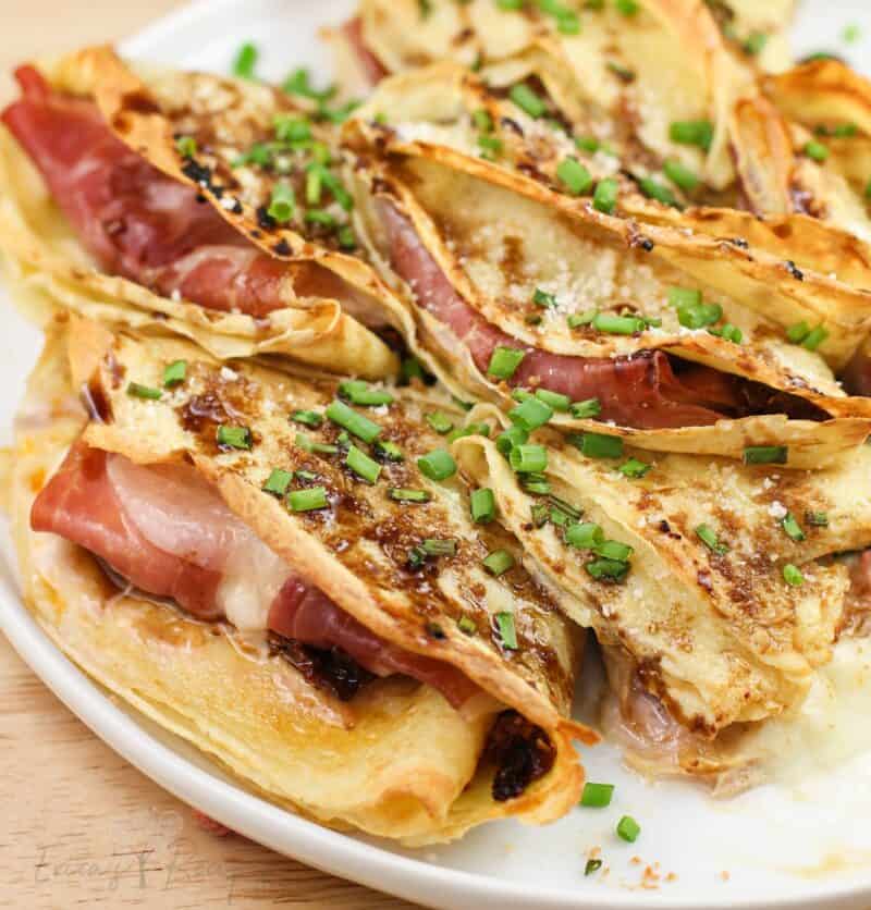 close view of prepared crepes showing prosciutto and melted cheese