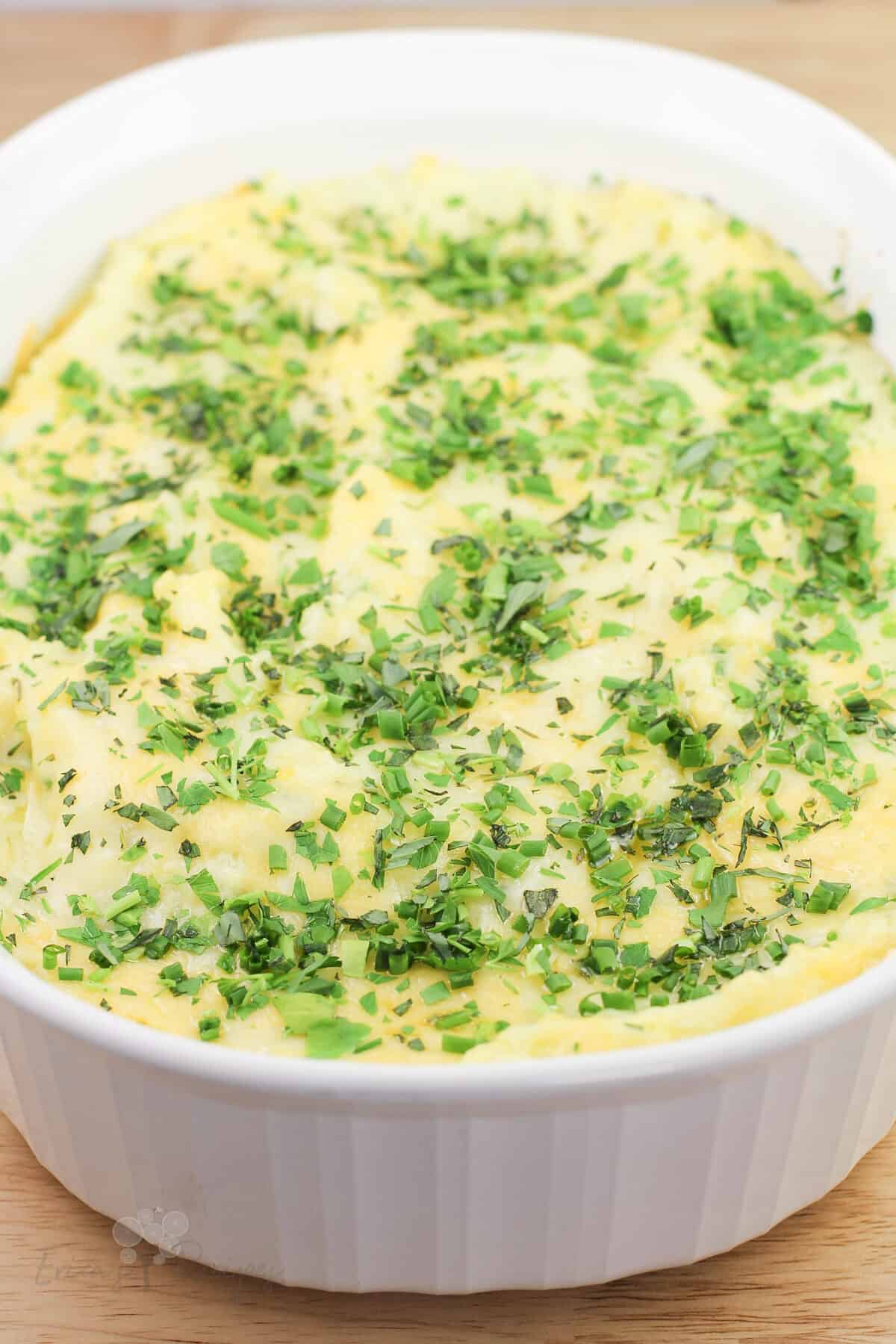 top, angled view into white dish of prepared guyere, garlic, and gouda mashed potatoes