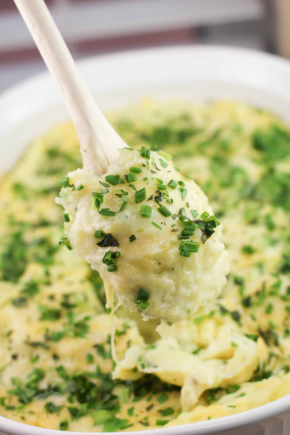 wood spoon holding gruyere and gouda mashed potatoes
