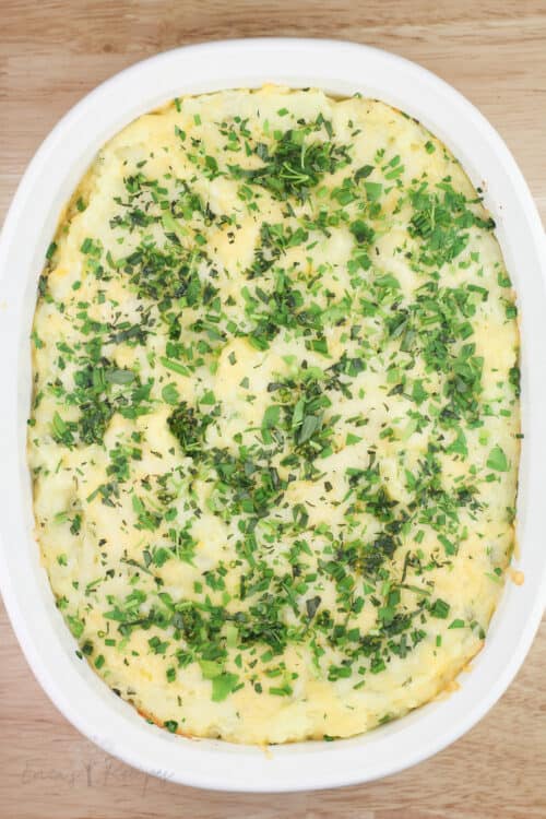 top down view of cooked mashed potatoes with cheese and herbs