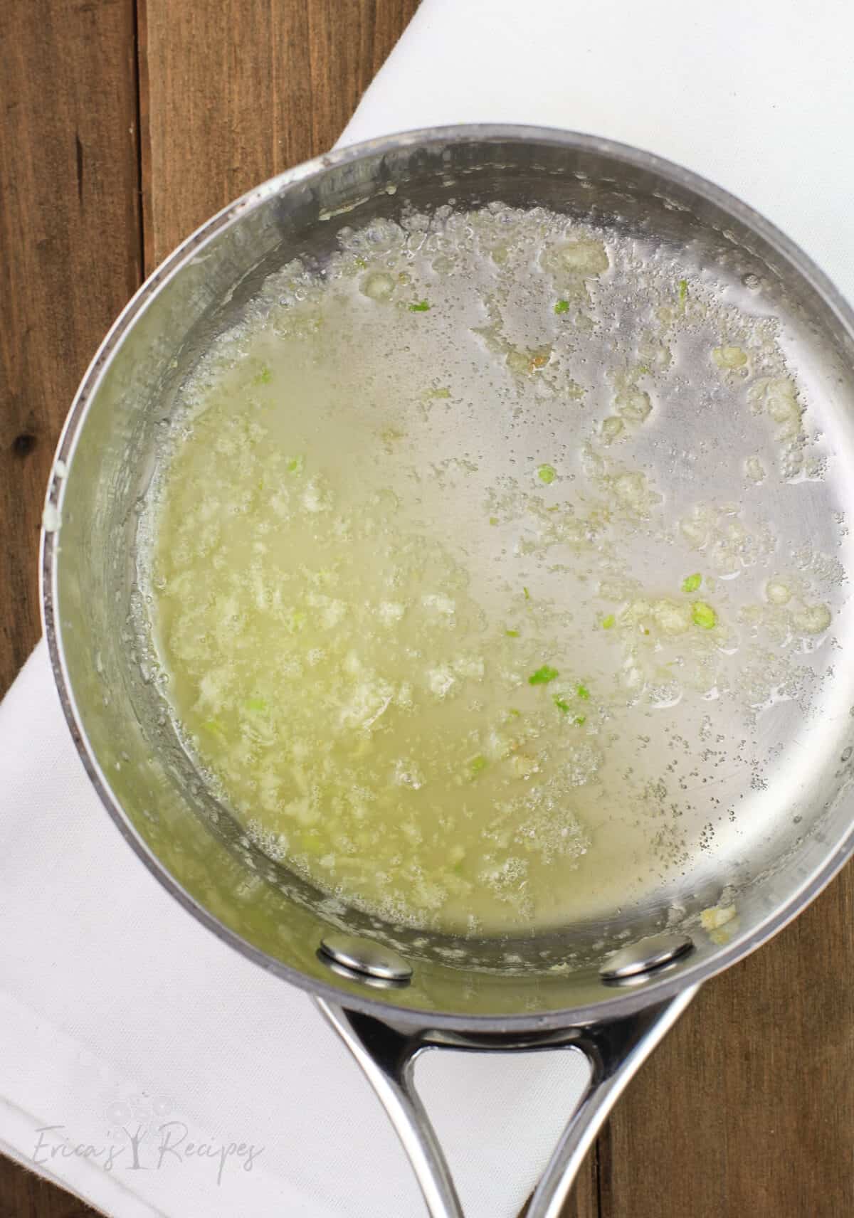 garlic and butter in sauce pan on white napkin