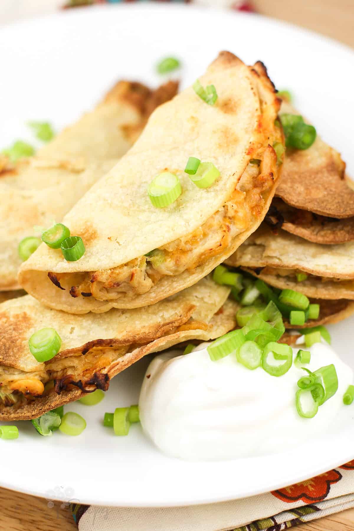 mini quesadilla on white plate topped with green onion