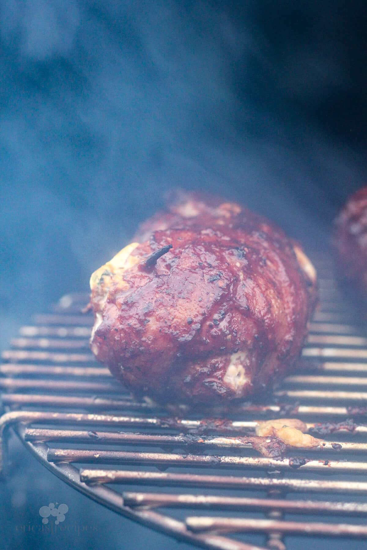 chicken bomb cooking on grill surrounded by smoke