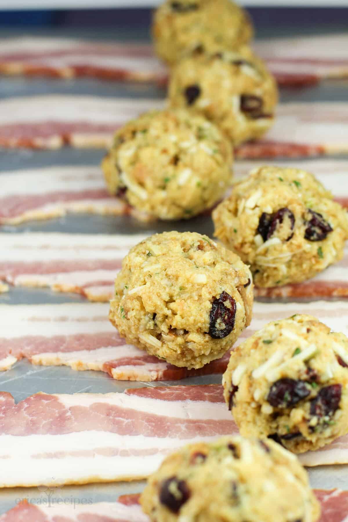 balls of stuffing on uncooked strips of bacon