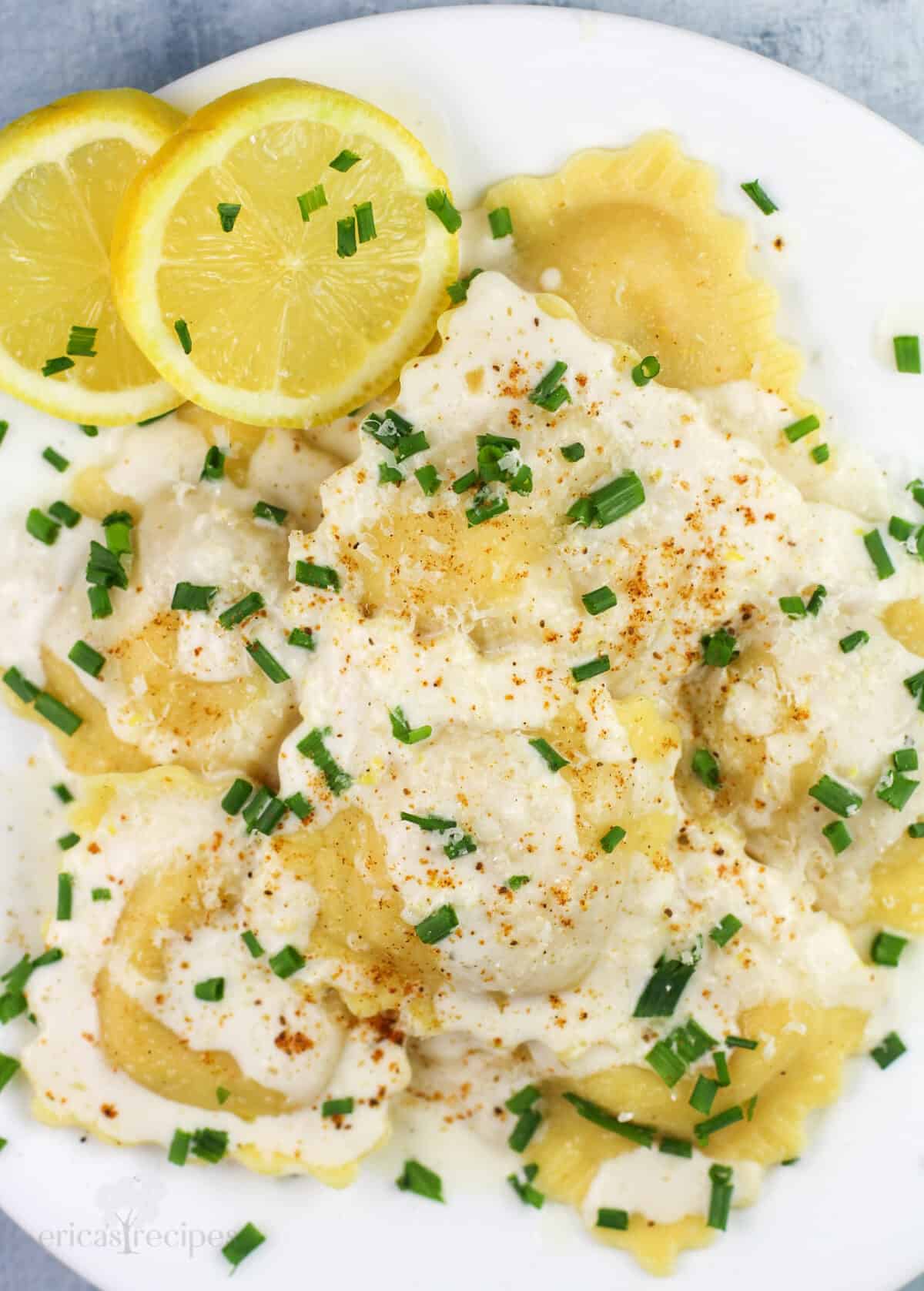 prepared ravioli on white plate with lemon slices on the side