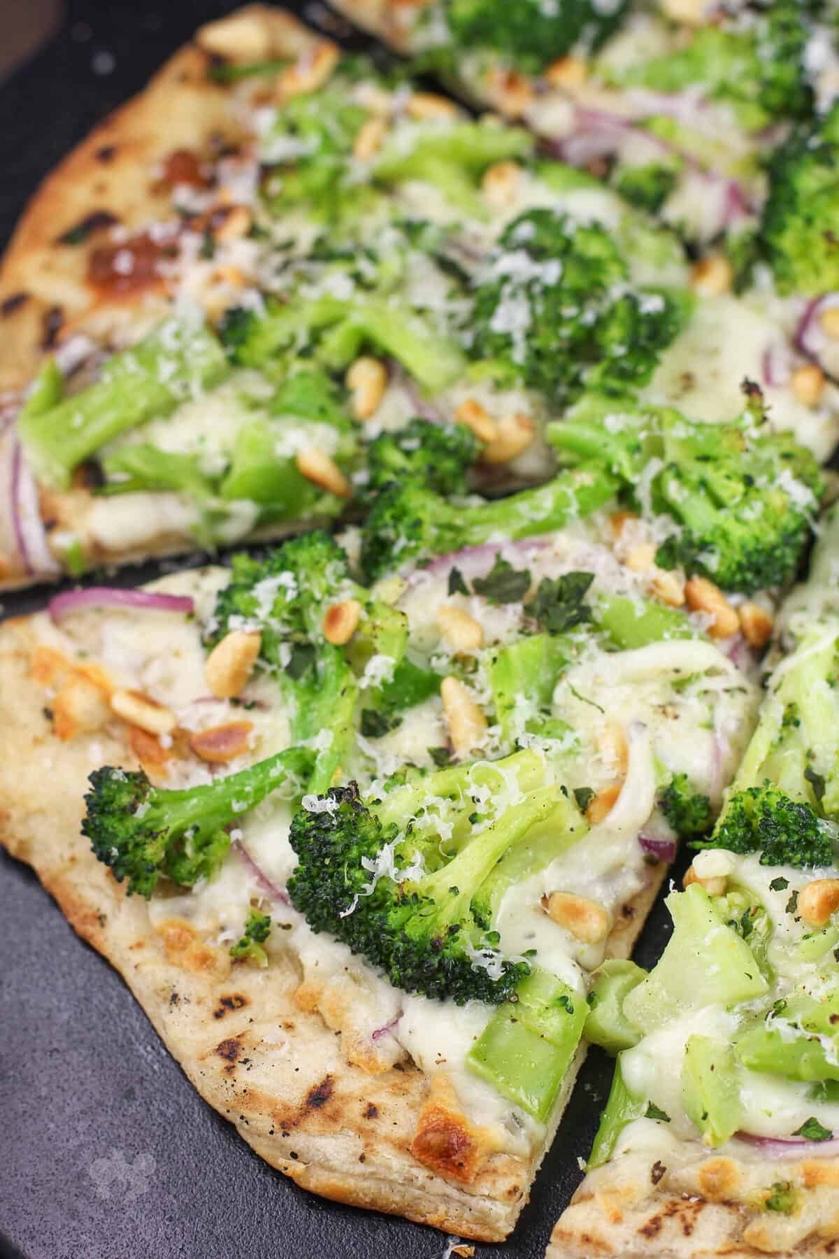 prepared broccoli pizza on black stone