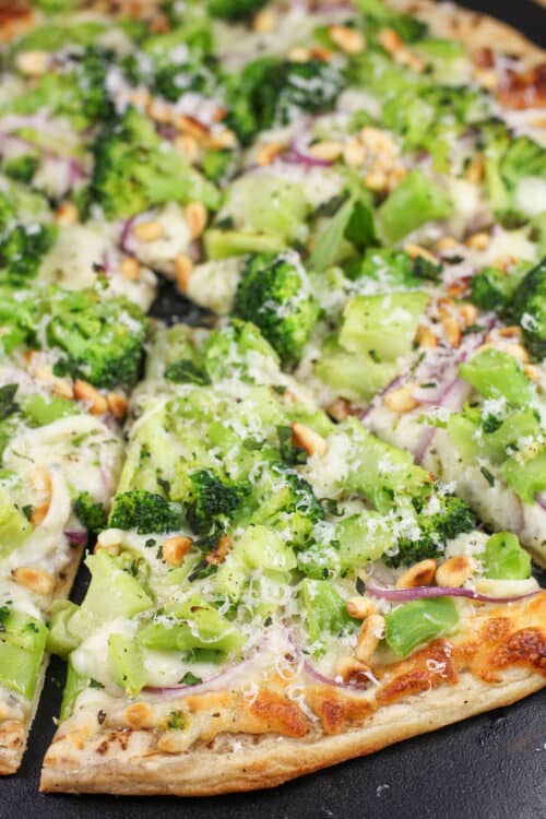 prepared broccoli pizza on black stone