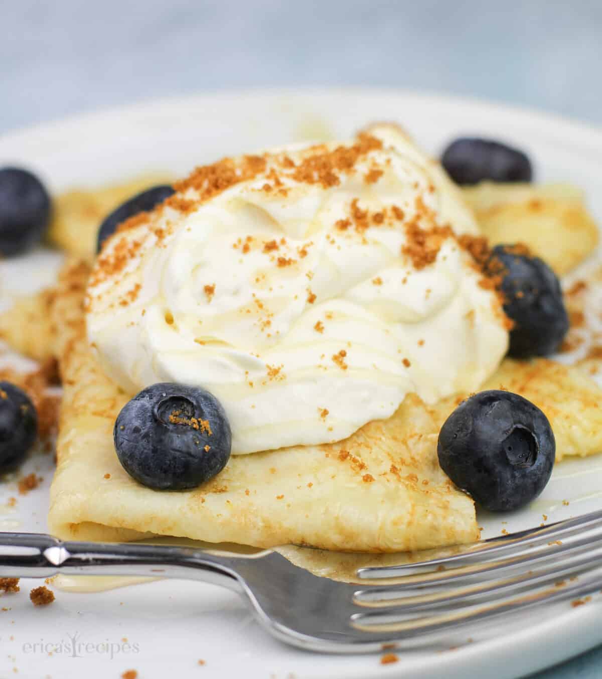 serving of prepared dessert crepes on white dish with fork