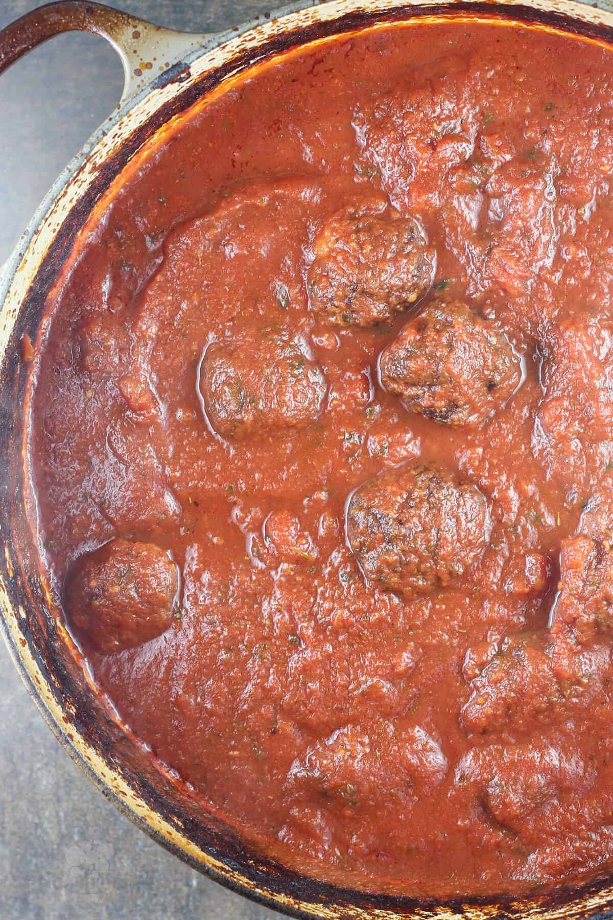 cooked meatballs in sauce in dutch oven