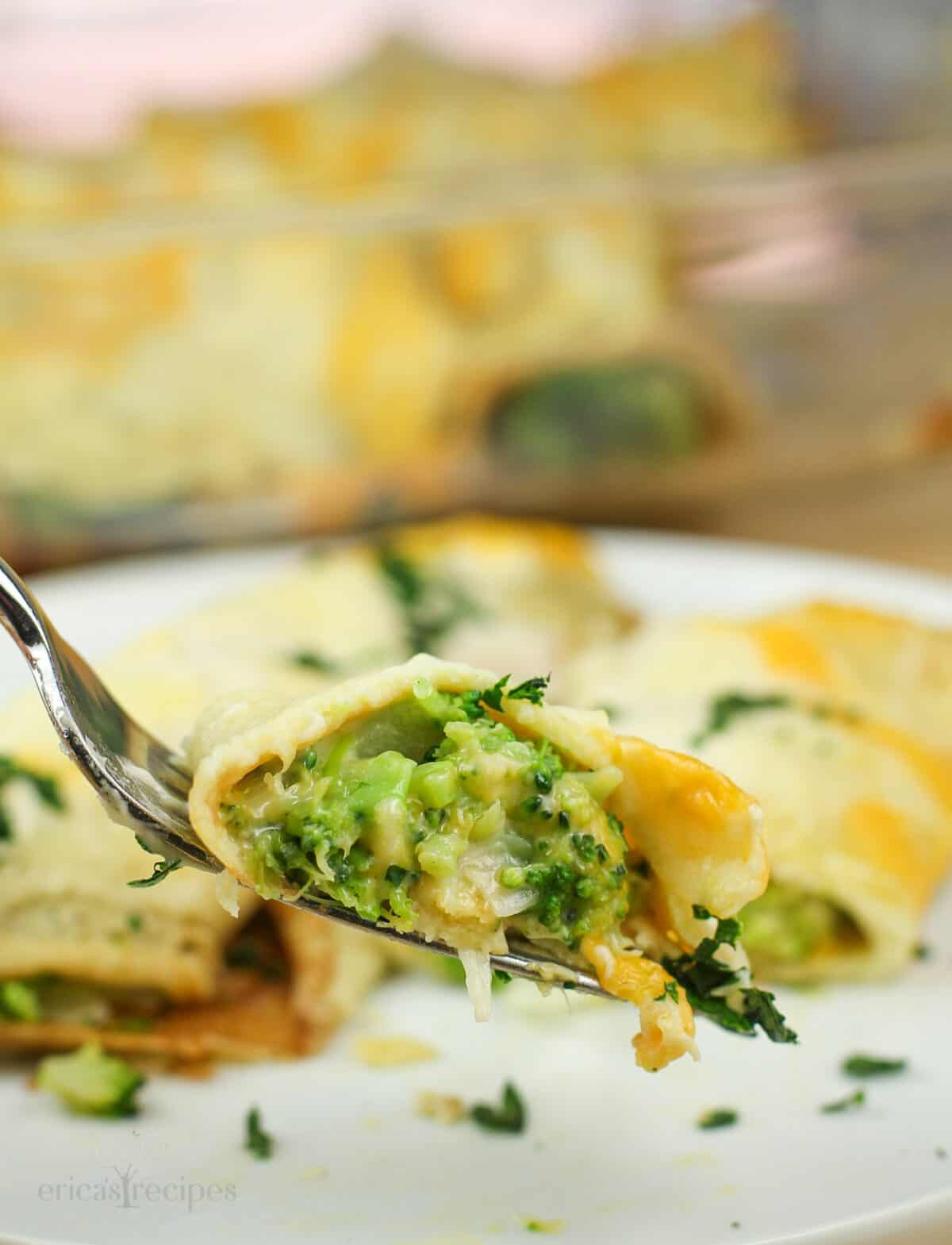 fork holding bite of crepe to show broccoli filling.