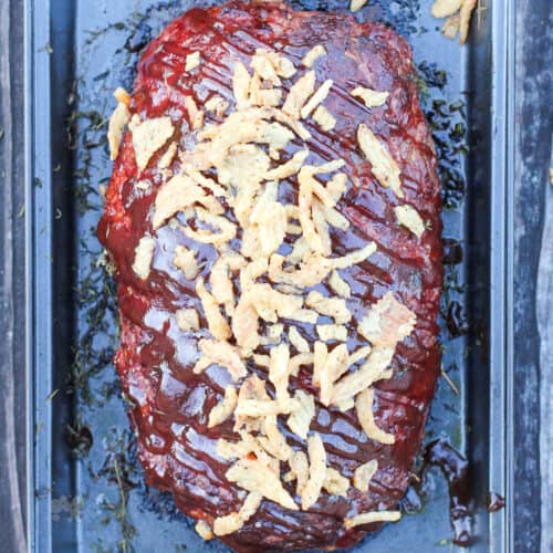 top down view of prepared meatloaf with bbq sauce and onions on top