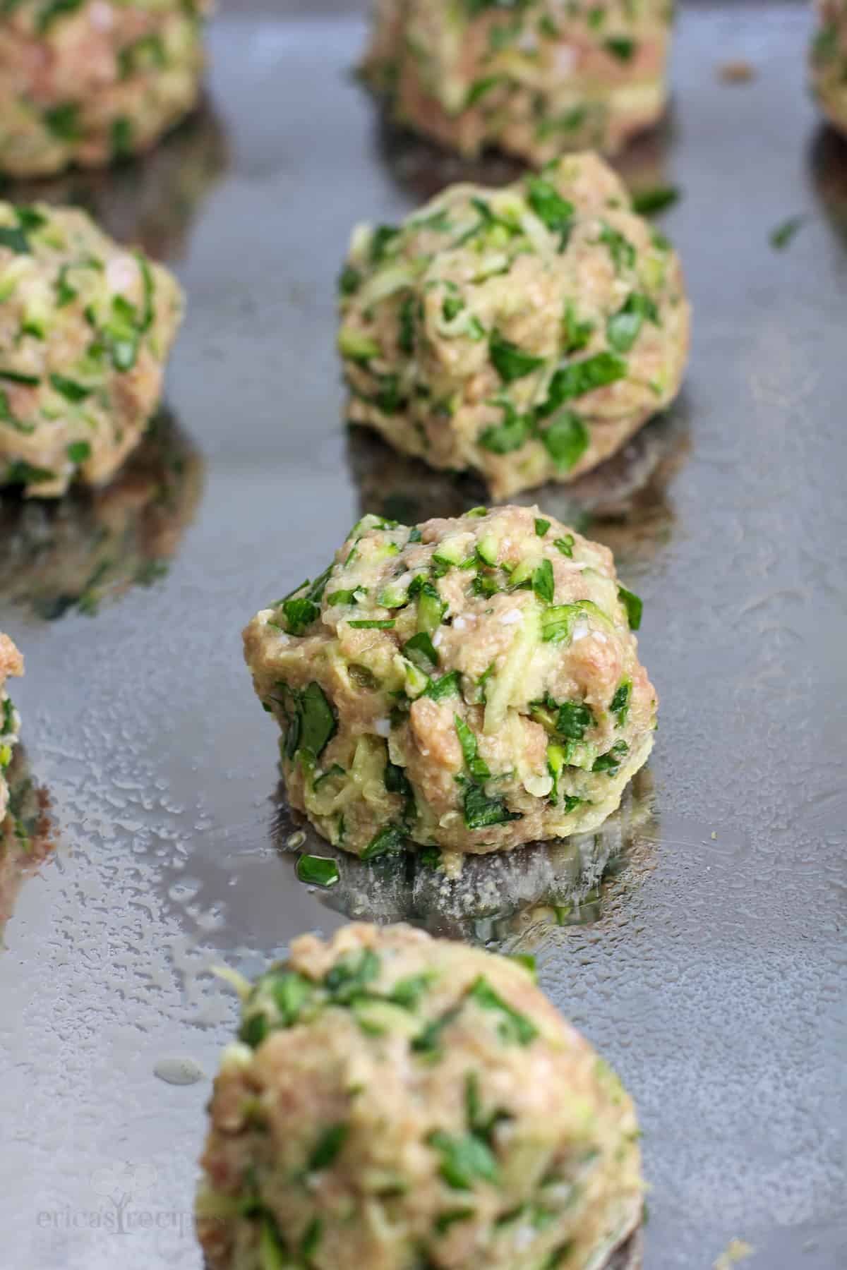 uncooked meatball on metal bake sheet