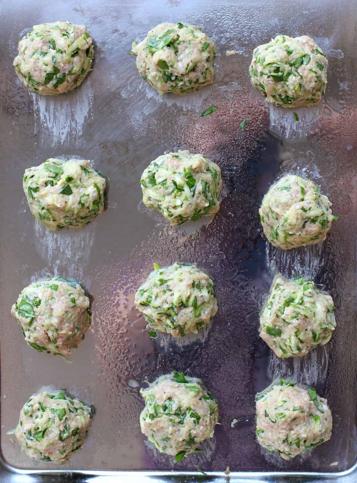 uncooked meatballs on bake sheet