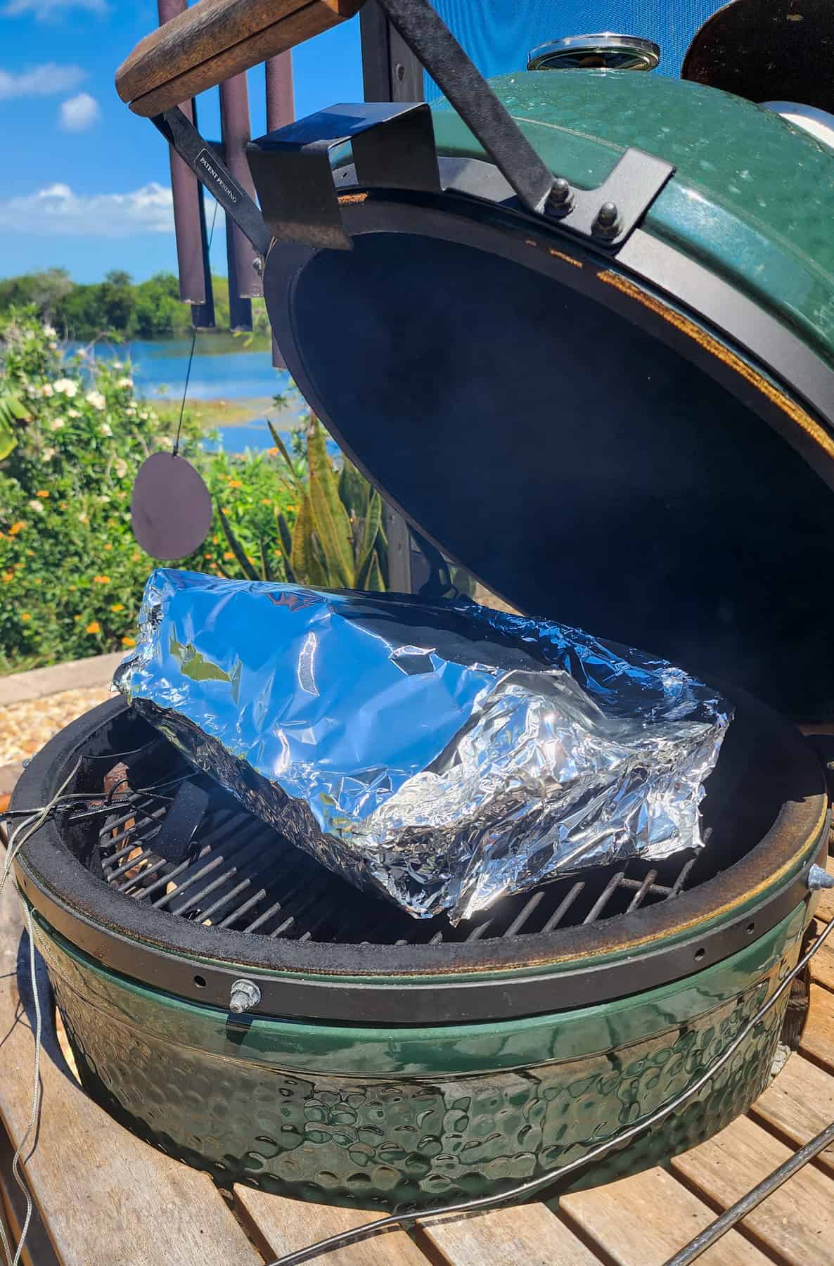 pan wrapped in foil on grill grate in Big Green Egg
