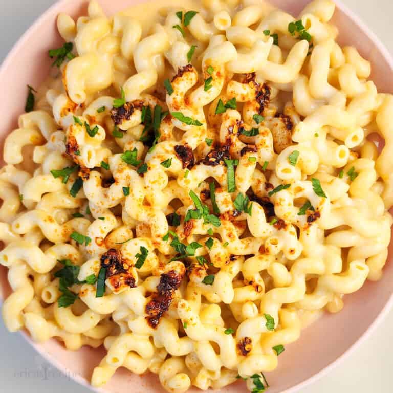 mac and cheese in a pink bowl on white background